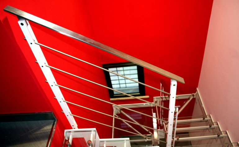 Scala interna con costole in ferro e gradini in vetro